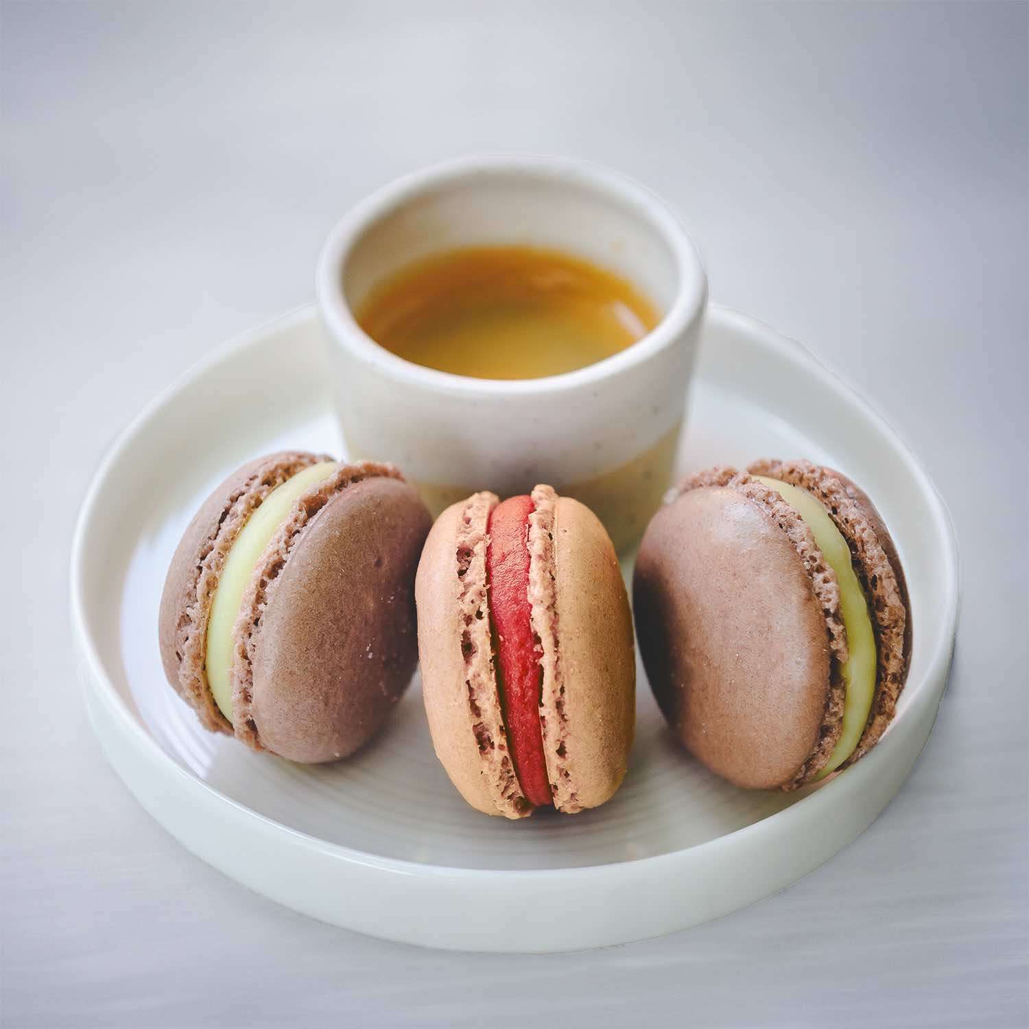 Bora Nera specialty coffee in cup with macarons cakes, side view